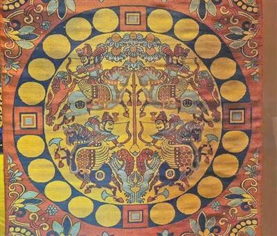 唐代“红地联珠团窠四骑士狩猎纹锦”（复制件）。