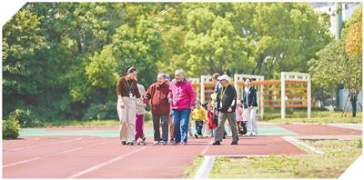 江苏省常州市，在工作人员陪同下，牡丹全龄汇居民和托育园小朋友在公园散步。人民网记者马天翼摄