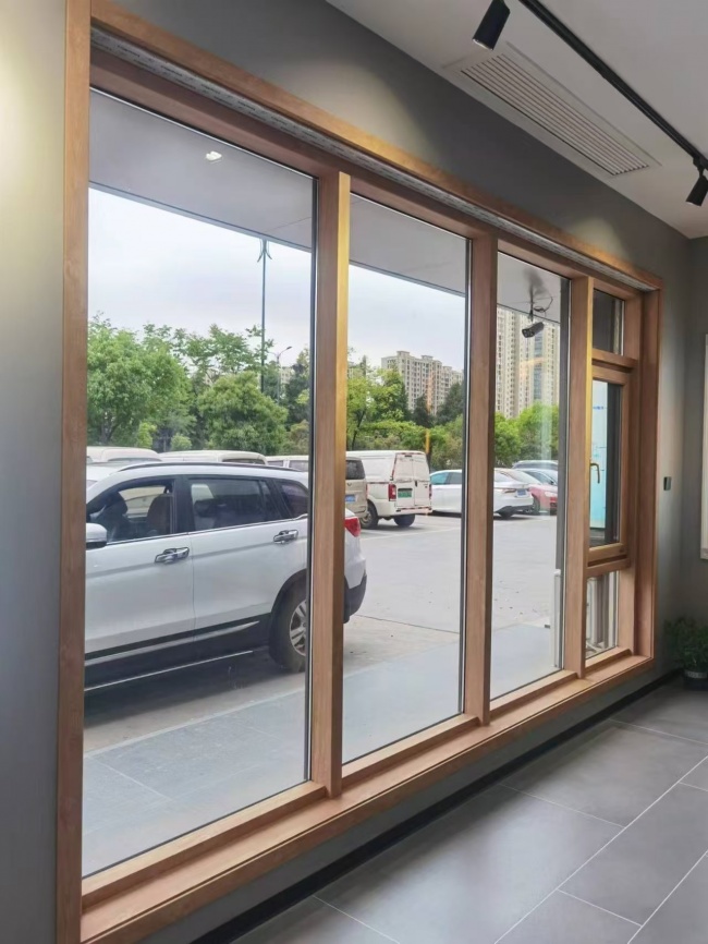 门店木纹色整窗与开启扇展陈，可用于观察开启方式与室内空间的关系；画面不是苍梧三期施工案例。